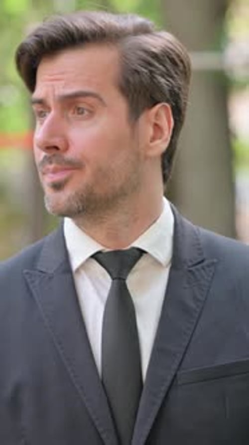 Serious Man in Suit Looks at his Watch