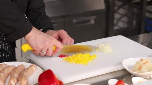 Chef dicing red pepper in commercial kitchen