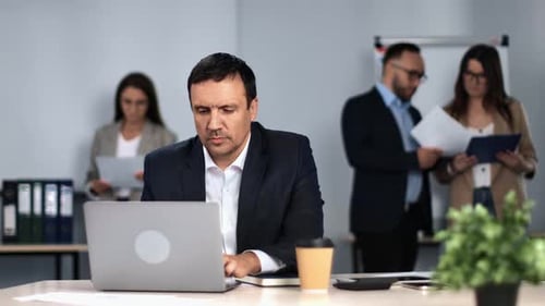 Man in Suit Working Laptop Desk Browsing Internet Chatting at Office Routine Colleagues Workspace
