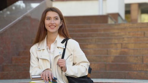 Smiling Student Poses on Campus Holding Books