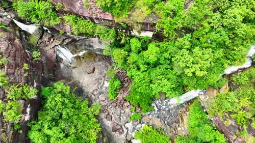 Lush tropical waterfall, aerial view, pristine beauty.