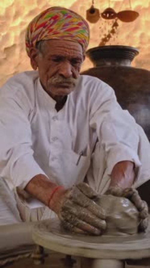 Potier indien au travail lançant le tour de potier et façonnant un récipient en céramique Rajasthan, Inde