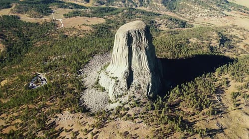 Aerial drone view of Devils Tower National Monument rising dramatically above the surrounding landsc