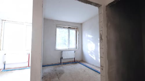 Rooms with white walls and new windows. Tour by the interior of a building under reconstruction.