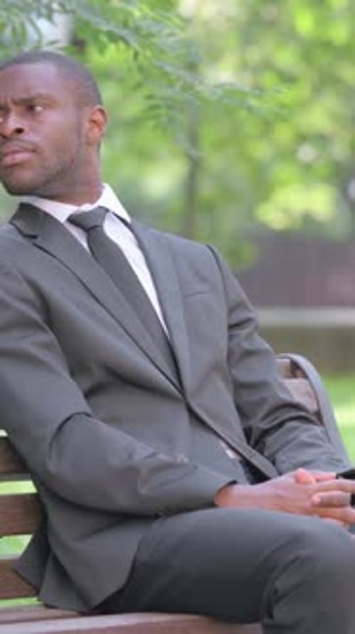 Man in Suit Sitting on Bench Checking Watch