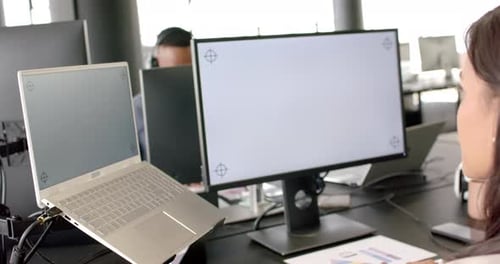 Working in office, person using laptop and desktop monitor for business tasks, copy space