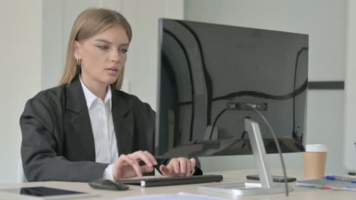 Young Woman Coughing at Her Office Desk