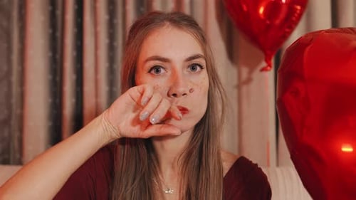 Young Woman Smearing Lipstick on Face With Hand