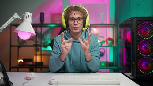 Young Adult Man Talking at Desk with Computer