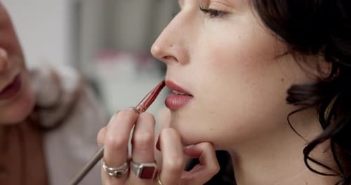 Makeup artist, backstage and lipstick with women in studio for cosmetics, fashion and makeover