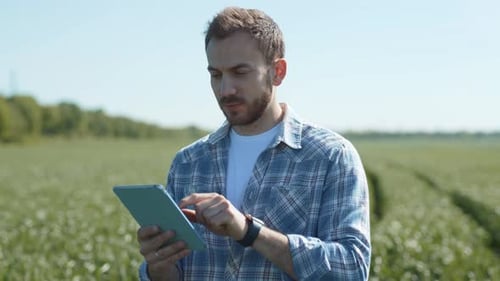Porträt eines glücklichen erfolgreichen Landwirts, der die landwirtschaftliche Ernte auf der grünen Wiese überwacht, Mann mit einem