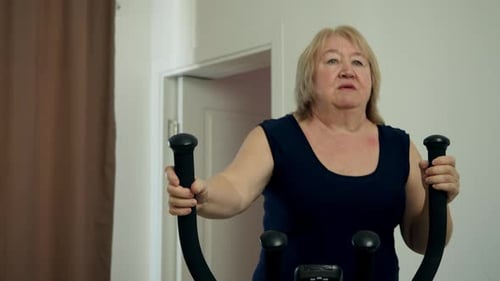 Woman Exercising on Elliptical Machine in Home