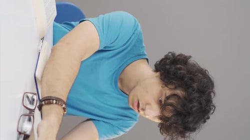 Stressed Young Adult Student Studying at Desk
