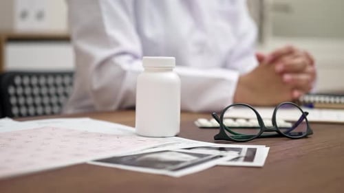 Close Up Female Doctor Holding Bottle of Pills Discuss Treatment and Prescriptions for the Patient
