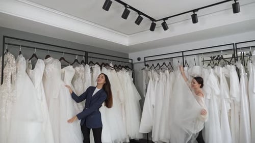 Duas lindas noivas escolhem um lindo vestido de noiva em um salão de casamento