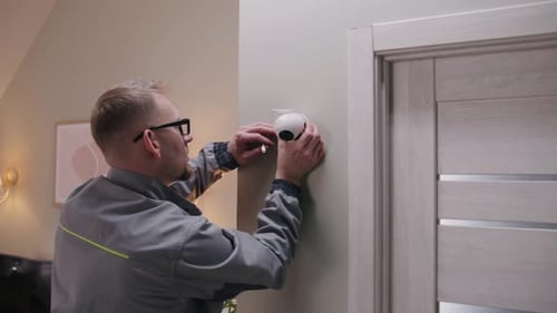 Installer Puts Security Camera on Wall Mount