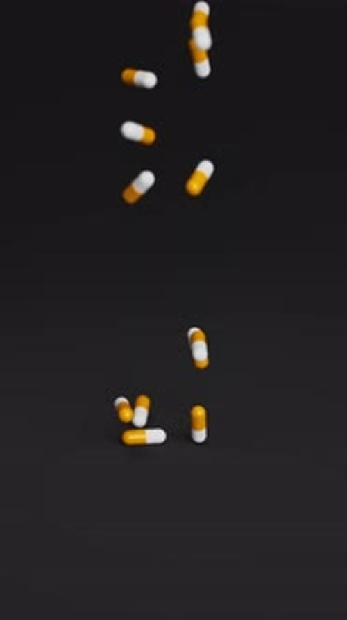 Pilules blanches et oranges tombant sur fond noir au ralenti Médicaments Pilules Comprimés Médicaments