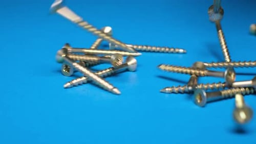 Gold Screws Falling on a Blue Background