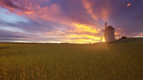 Dramatic Old Wooden Windmill on a Hillside Field at Fiery Sunset or Sunrise
