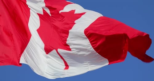 Canadian Flag Waving Against a Blue Sky