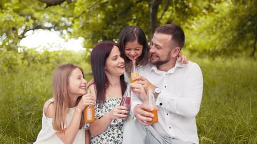 Happy Family Enjoying Picnic in a Green Park