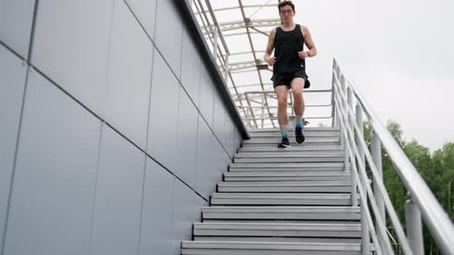 Man Runs Down Staircase Outside Urban Building
