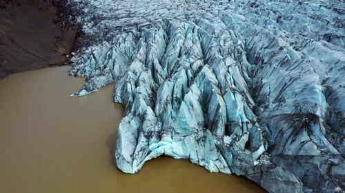 Blueish Glacier Of Svinafellsjokull Between Mountains In Iceland. - aerial