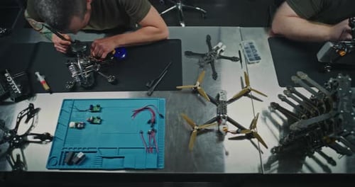Les techniciens assemblent et placent soigneusement le Drone FPV finalisé dans une boîte sur un établi en métal