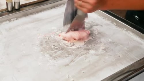 Preparing stir-fried ice cream rolls with strawberry at freeze pan. Rolled ice cream, hand made ice