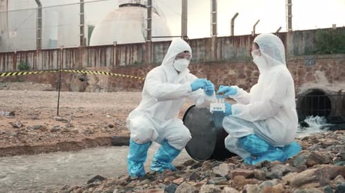 Ecologist Sampling Water From the River with Test Tube