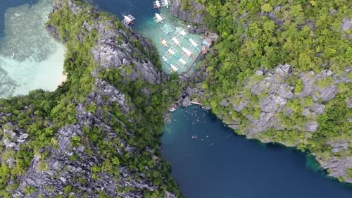 Panoramic bird's-eye aerial of tour boats and people at Barracuda lake, Coron