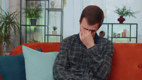 Young Adult Man Crying on Sofa