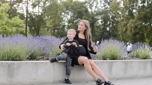 Famille heureuse. Jeune mère enceinte avec son fils dans le parc. La famille passe du temps ensemble