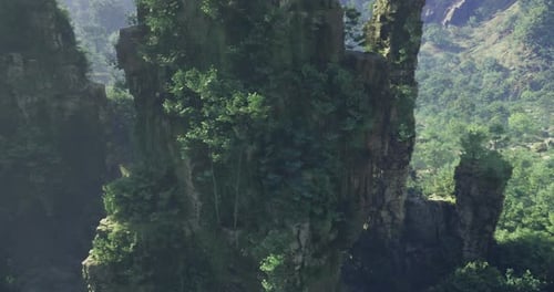 Lush Greenery Enveloping Towering Rock Formations in a Serene Landscape