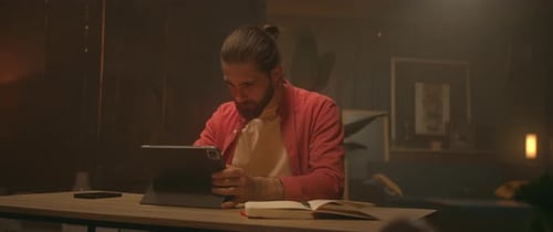 Young Adult Using Stylus and Tablet Device at Desk