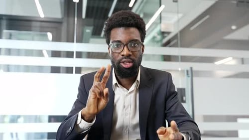Webcam view. Confident african american businessman in a formal suit talking on a video call looking