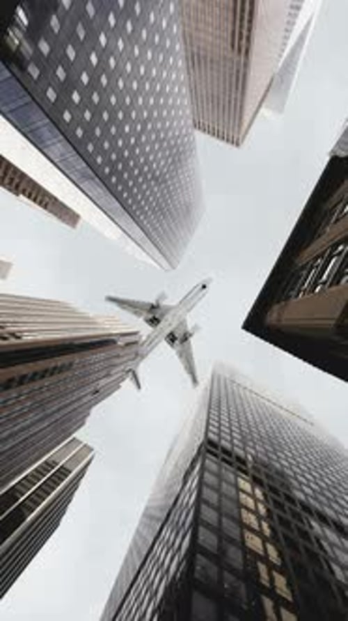Airplane Flying Over City Business Buildings