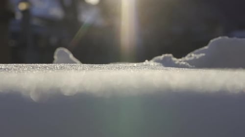 Macro Shot Of Sun Flares Reflecting On Frozen Snow And Ice During Winter