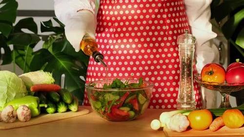 Vegetable fresh summer salad in bowl with tomatoes. Pour olive oil