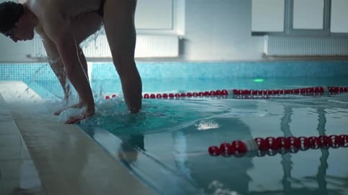 Vista lateral Jovem emergindo da piscina se afastando em Câmera lenta