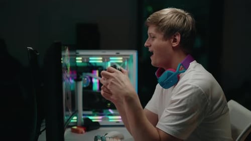 Enthusiastic Young Man Playing Video Games at Night