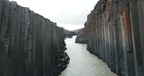 Surreal Landscape and Natural Beauty of Iceland. Basalt Column Canyon and Glacier River on Gloomy Da