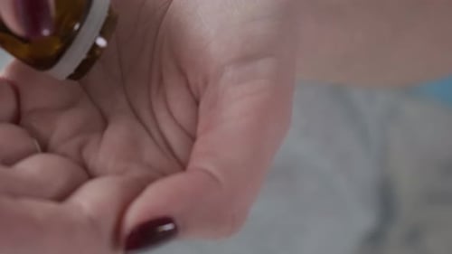 Hand Pours Medicine Pills Into Palm