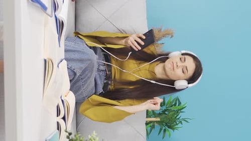 Happy Young Woman Listening to Music at Home