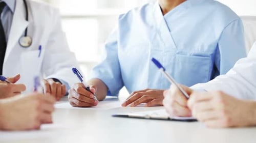 Doctors hands write meeting notes teamwork inside hospital healthcare concept