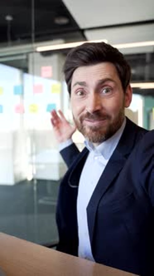 Friendly Business Man Waving and Smiling at Camera