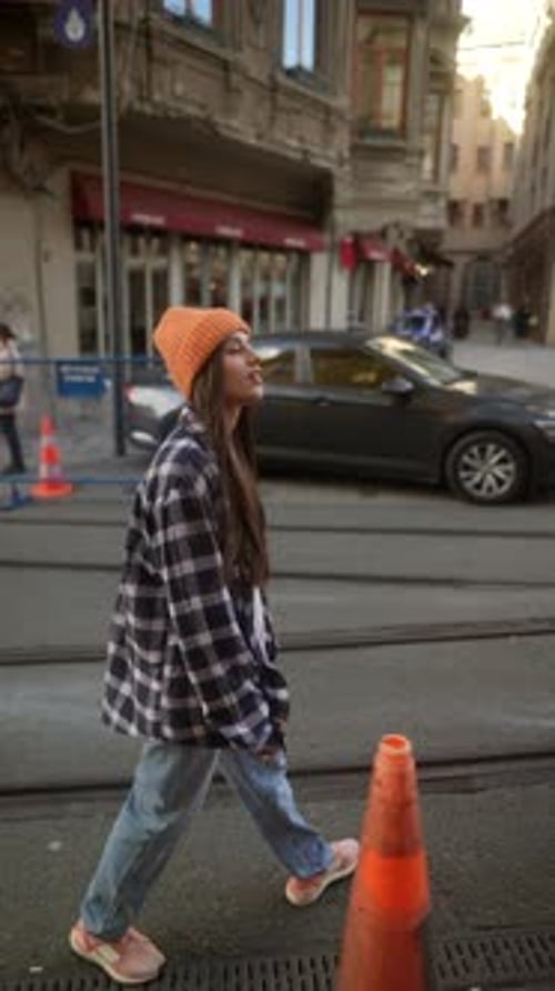Woman Takes Pictures on Urban Sidewalk