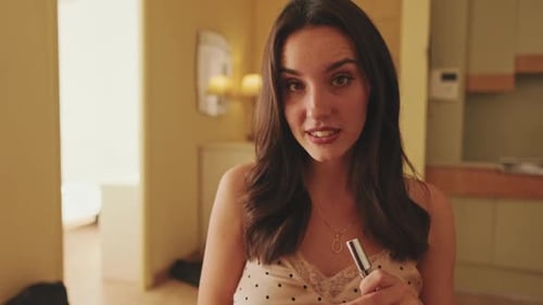 Woman Demonstrates Lip Makeup Application in Home