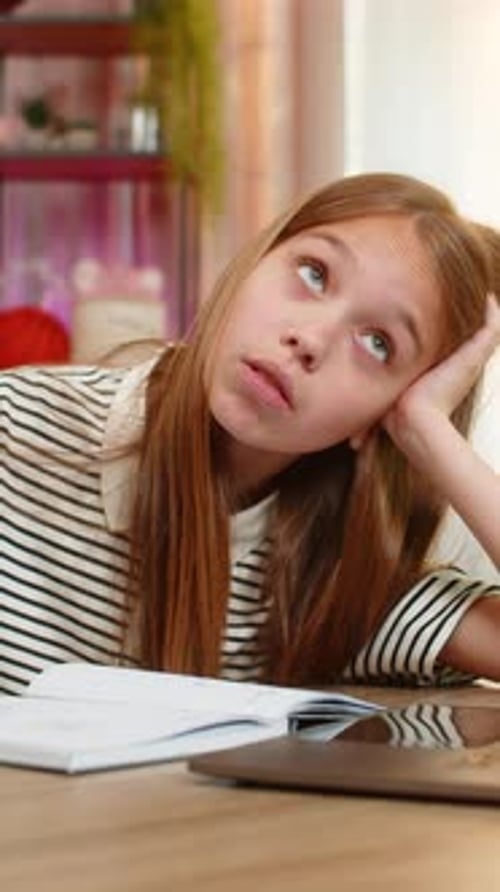 Child Girl Kid Doing Lazy Homework at Home Sitting Tired at Table with Laptop During Online School