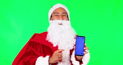 Man, Santa and phone mockup on green screen for Christmas advertising against a studio background